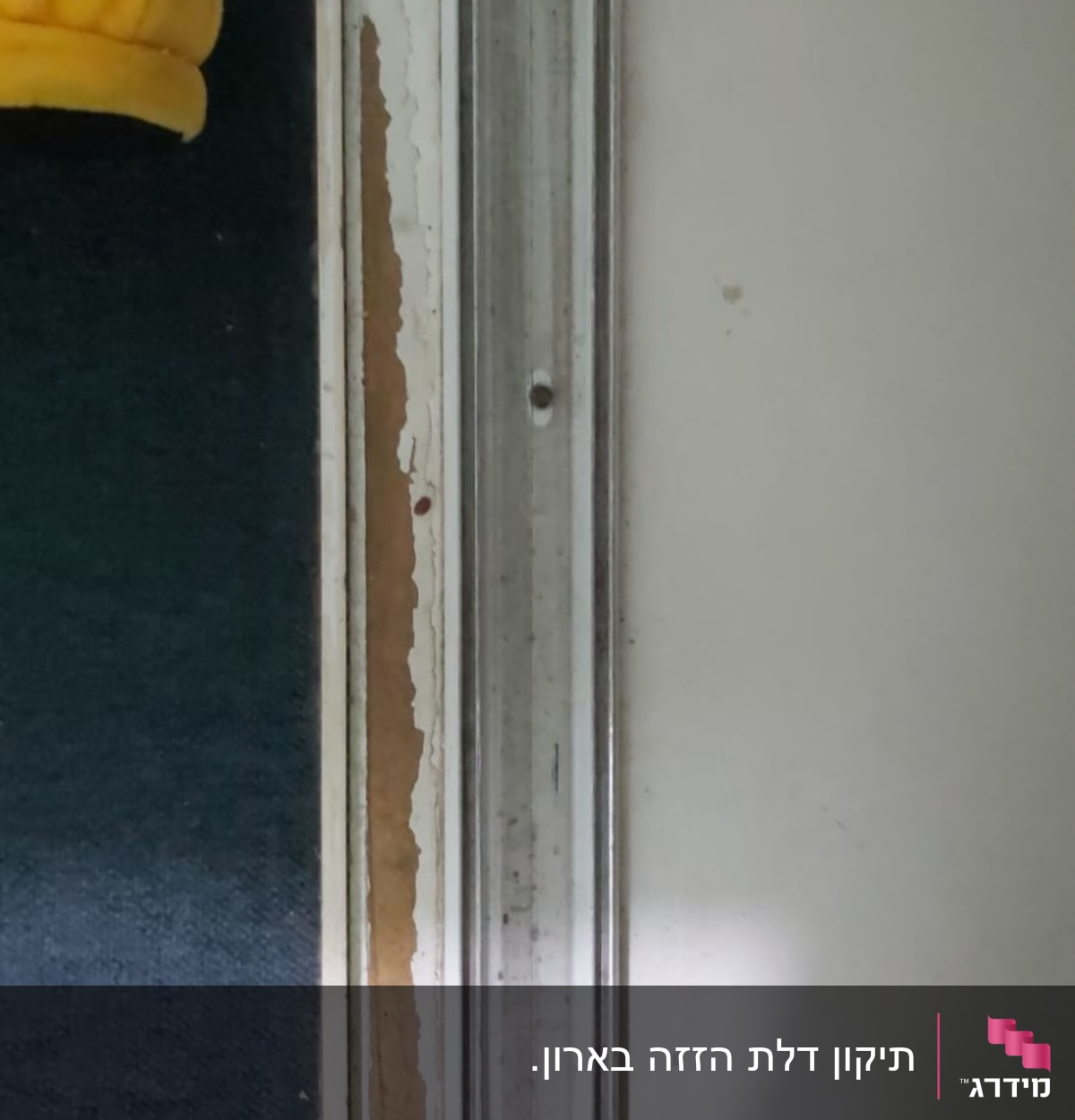 מסילת מתכת על קיר לבן עם סימני שחיקה